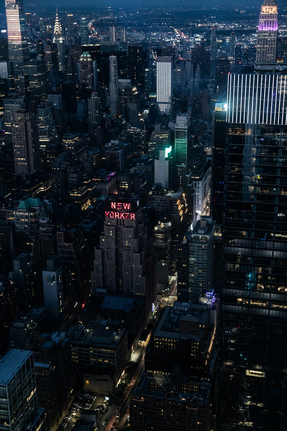 a view of a city at night from the top of a skyscraper