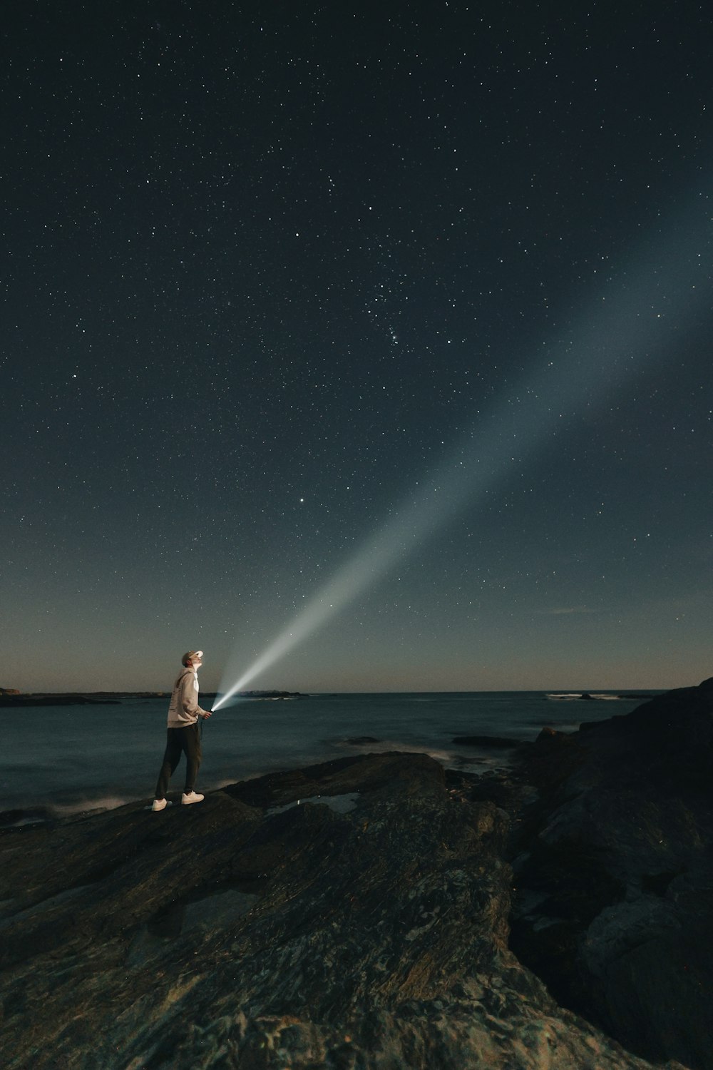 a man standing on a rock with a flashlight in his hand