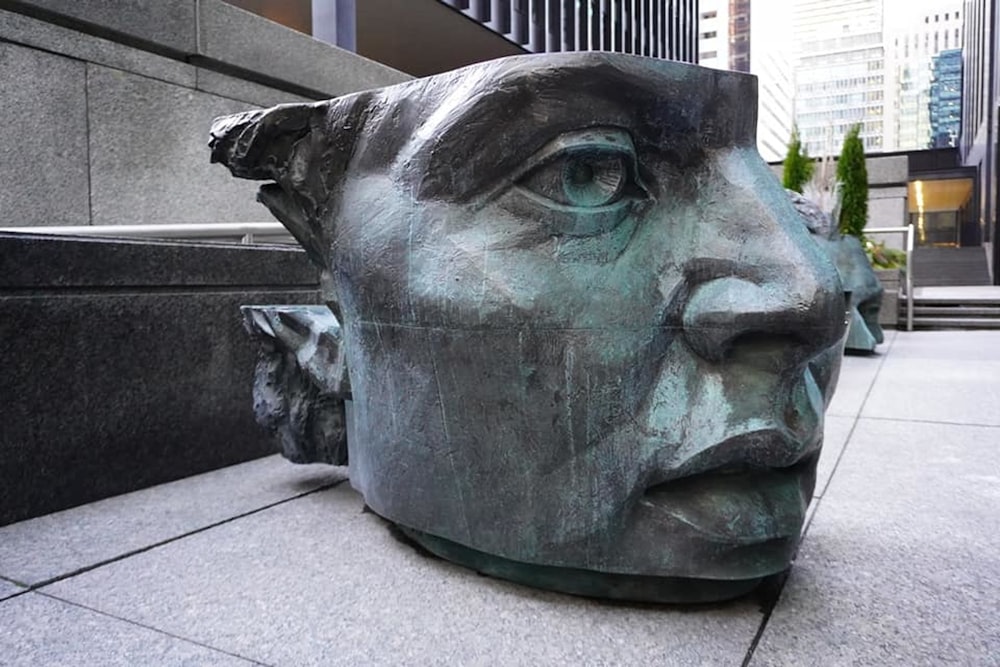 a statue of a man's head on a sidewalk