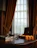 A cozy, softly lit room with a neatly arranged adult toy and silk stocking on a wooden table.