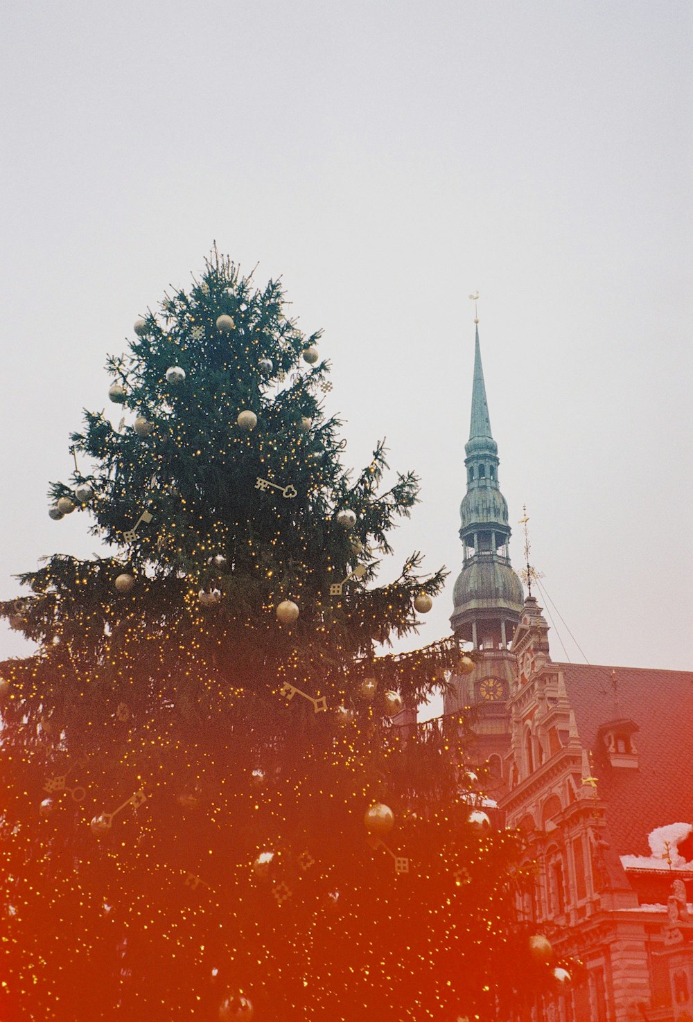 a large christmas tree in front of a church