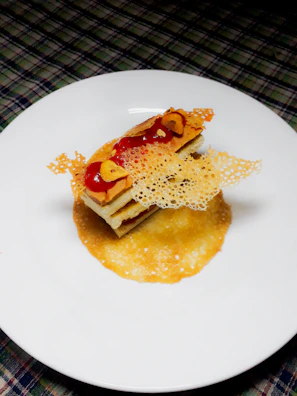 A beautifully plated dessert with delicate garnishes on a minimalist white plate.