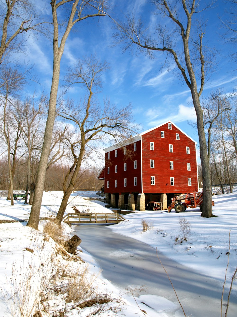 a red barn in the middle of a snowy field