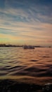 a large body of water with a boat in the distance