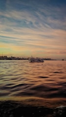 a large body of water with a boat in the distance