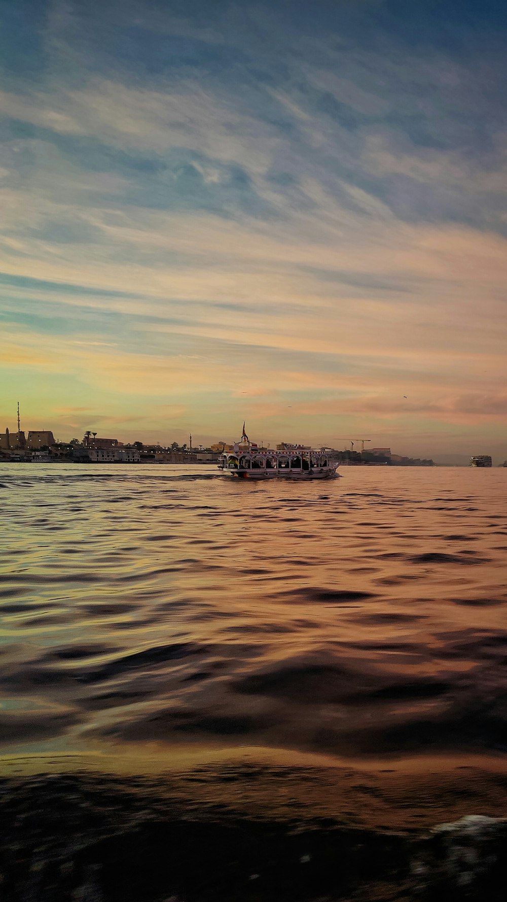 a large body of water with a boat in the distance