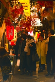 A lively street scene in a bustling Japanese neighborhood with lanterns and shops.