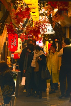 A lively street scene in a bustling Japanese neighborhood with lanterns and shops.