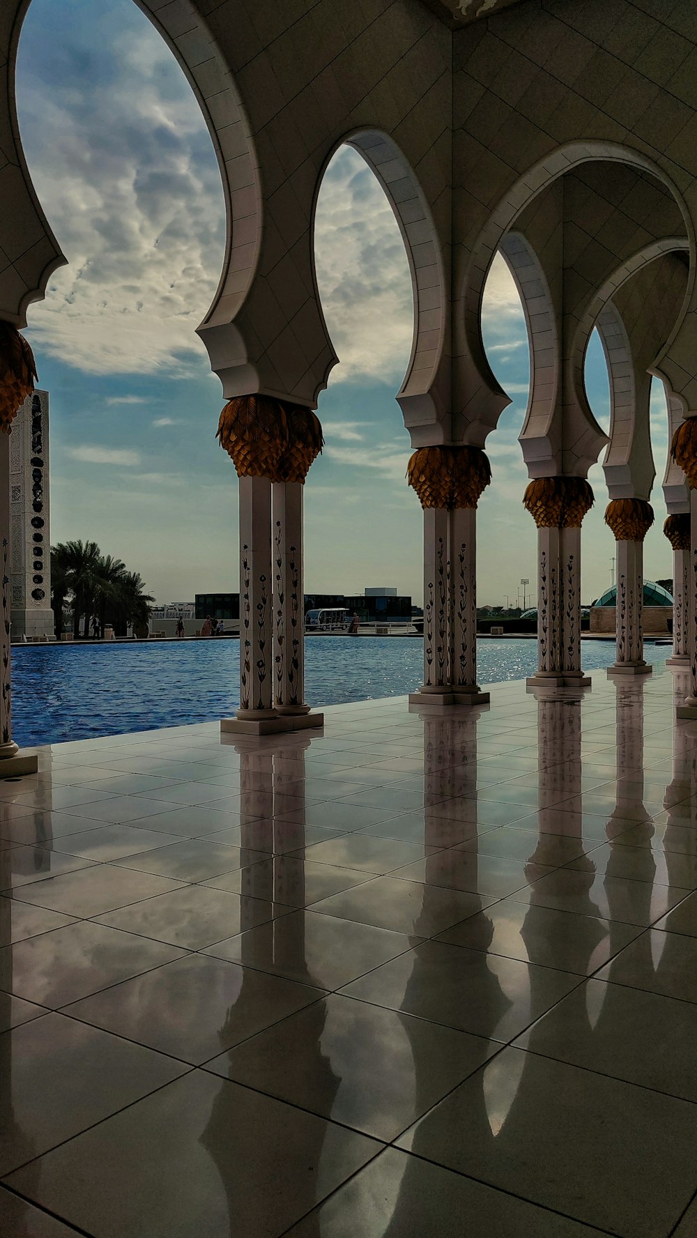 a view of a pool through a row of arches