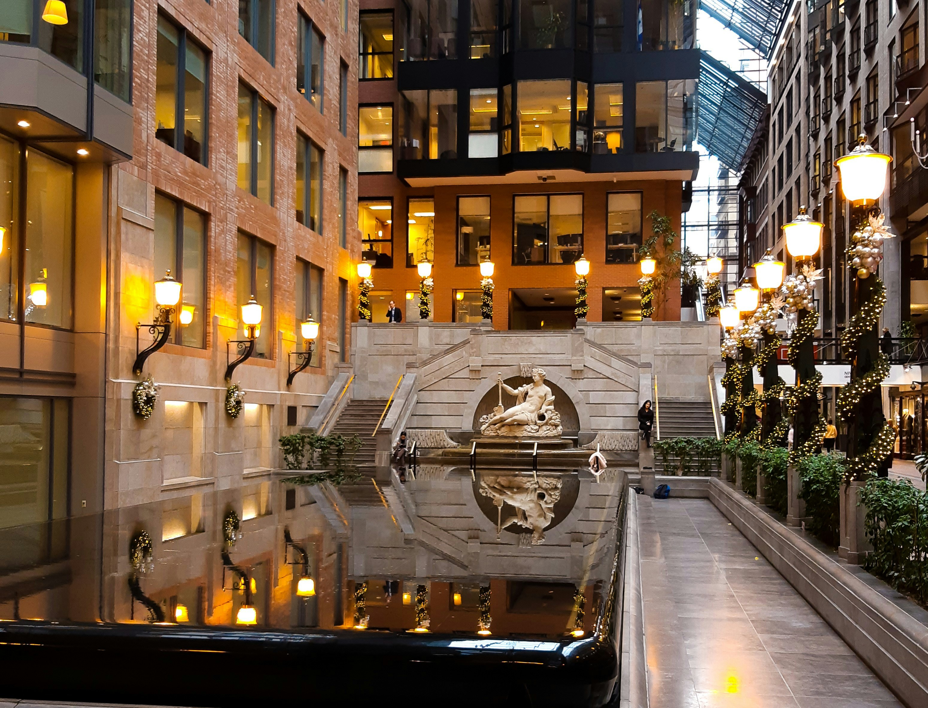 a building with a fountain in the middle of it, Inside the Centre de Commerce of Montreal at station Victoria-Square OACI lies a beautiful fountain and Greek-era-like sculpture