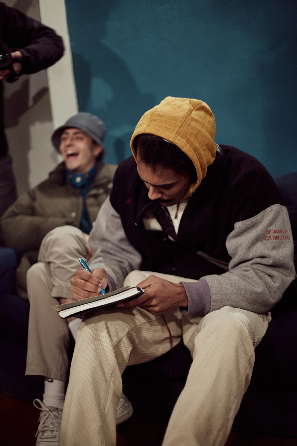 a man sitting on a couch writing on a book