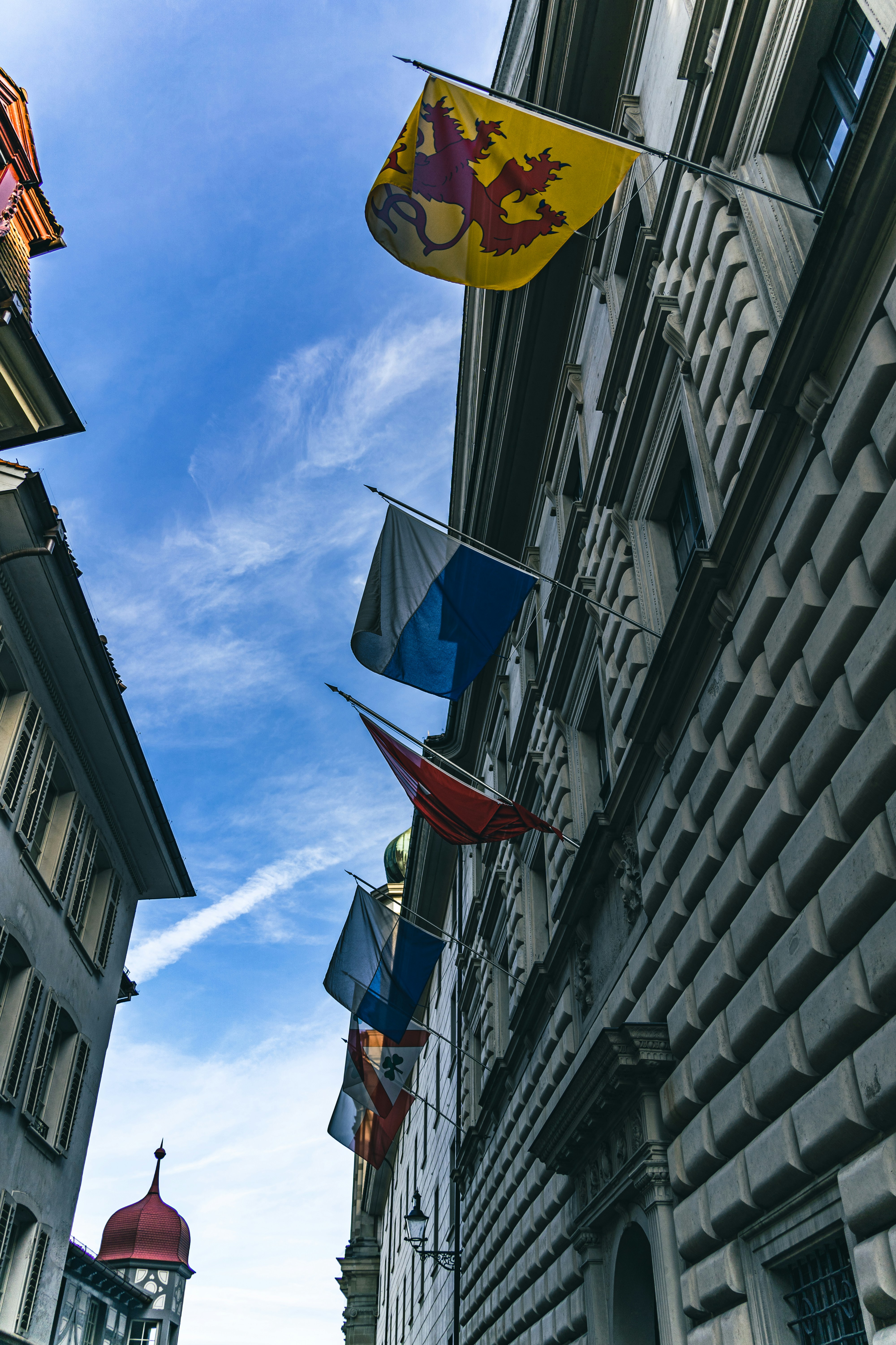 a row of flags hanging from the side of a building