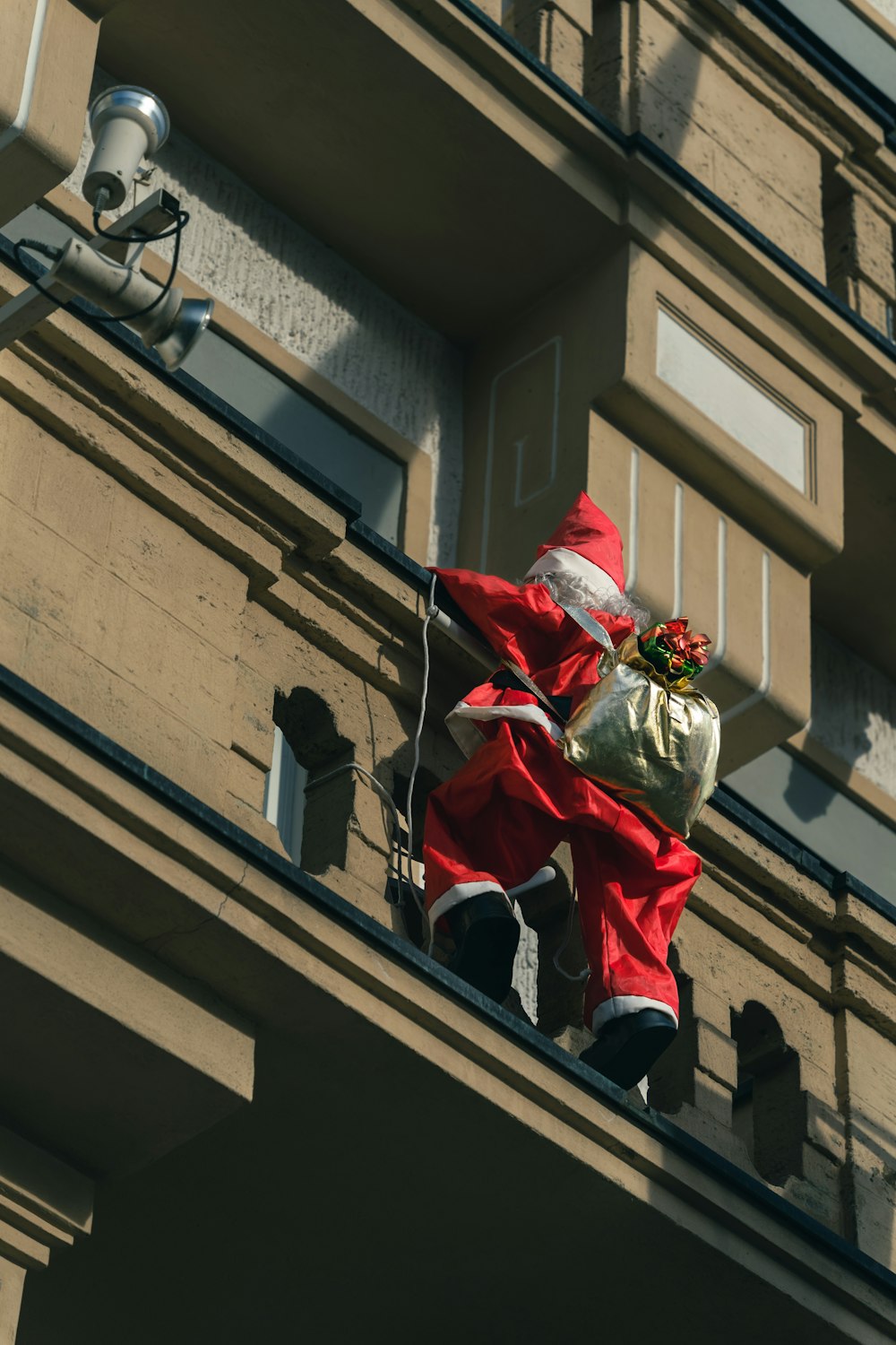 a man dressed as santa claus climbing a building