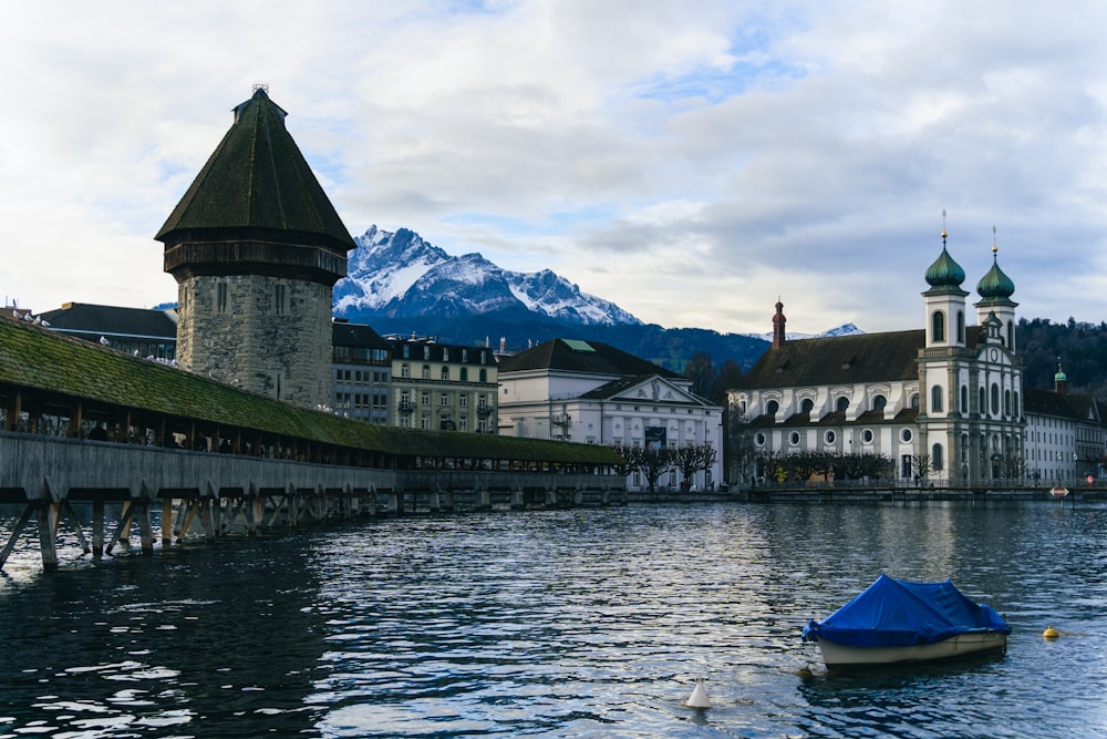 a boat floating on top of a lake next to a tall building