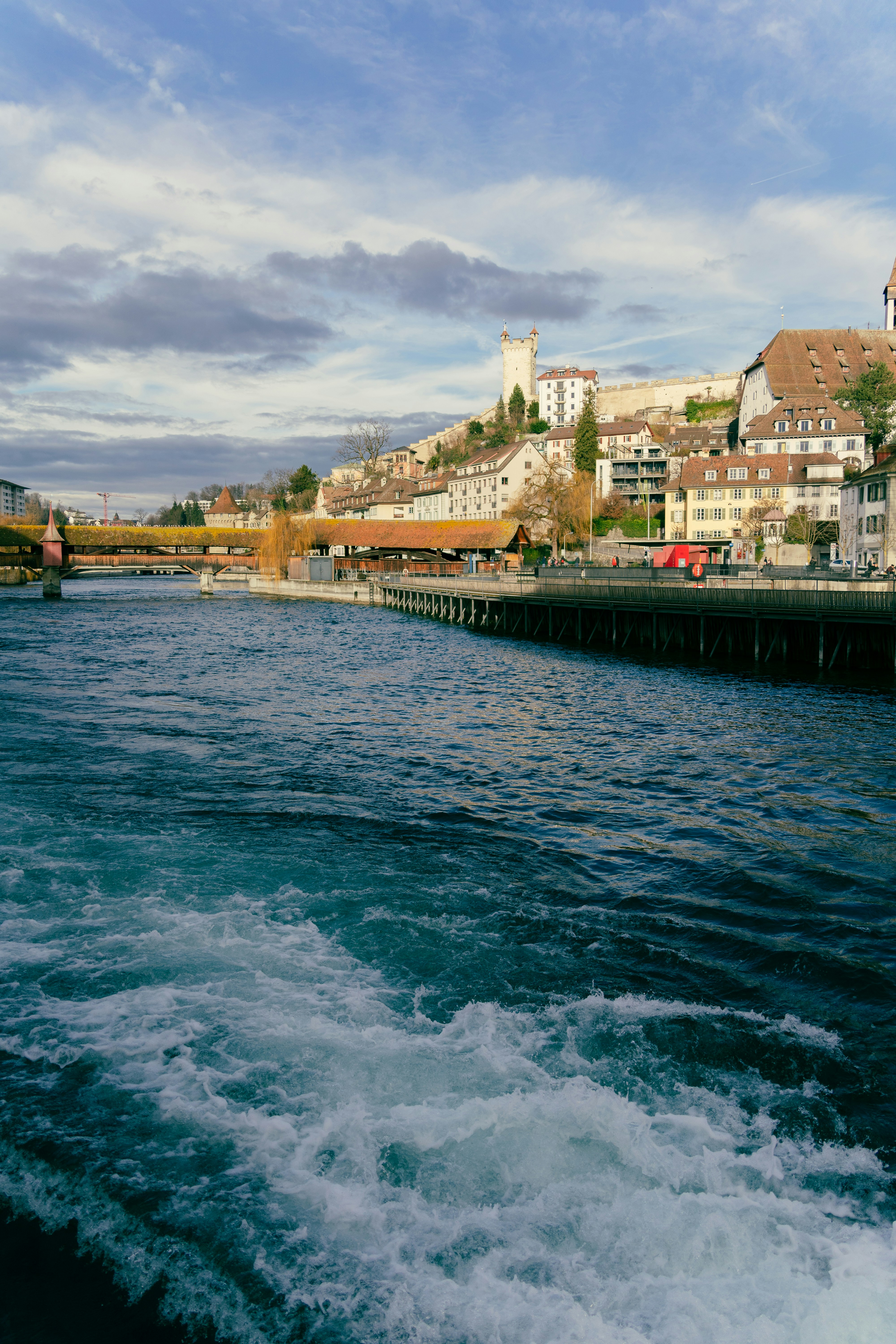 a boat traveling down a river next to a city