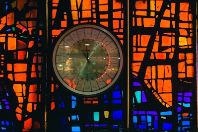 A close-up of a round epoxy wall clock with swirling blue and gold resin patterns.