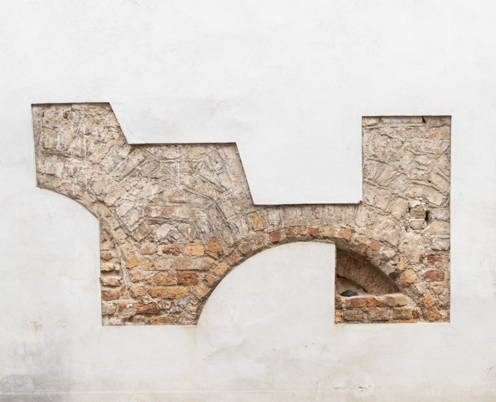 a man riding a skateboard past a brick wall