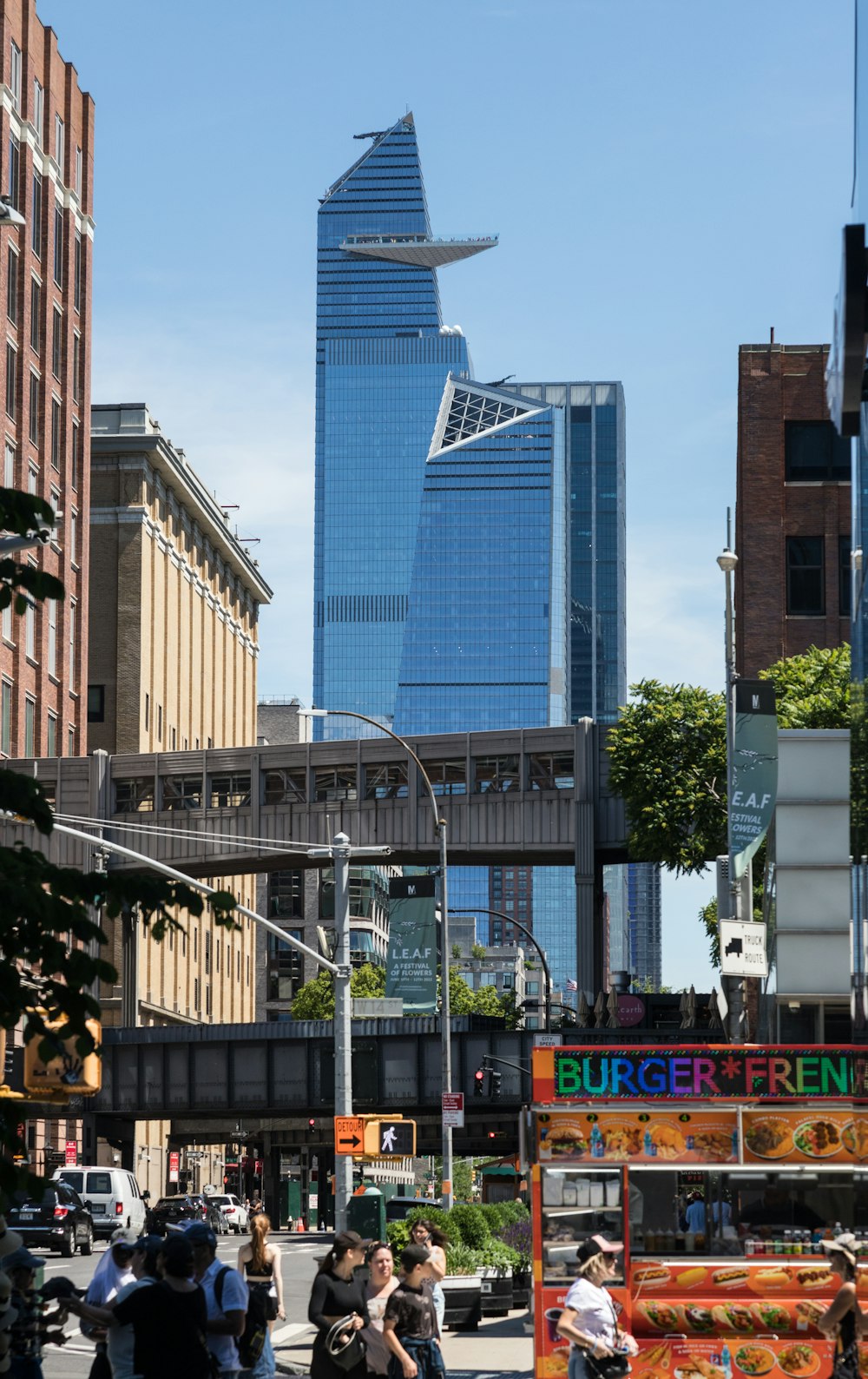 a group of people walking down a street next to tall buildings