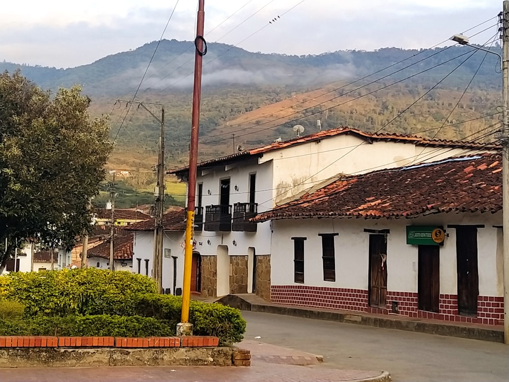 a street with a few buildings and a mountain in the background