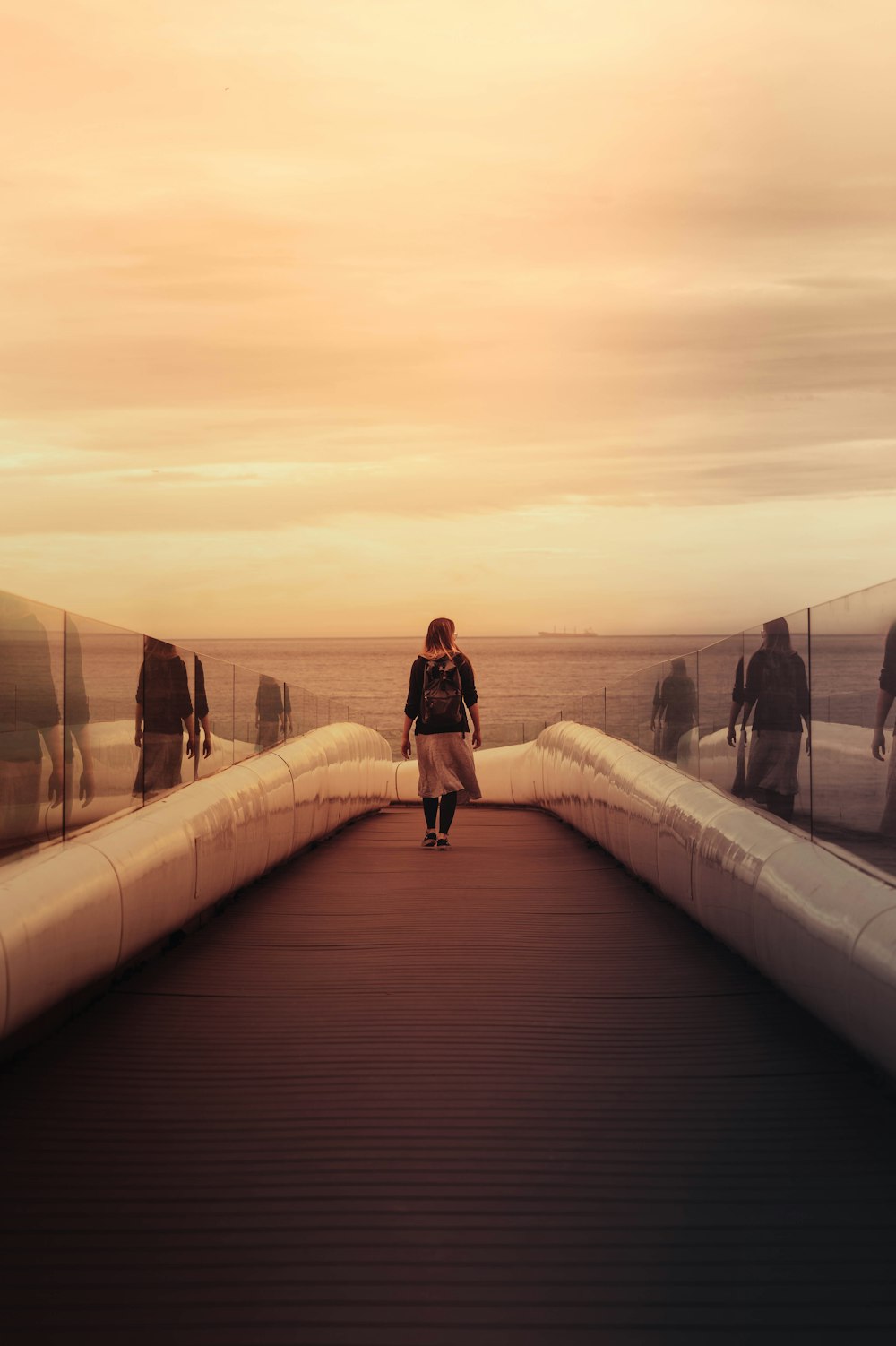 a group of people walking across a bridge