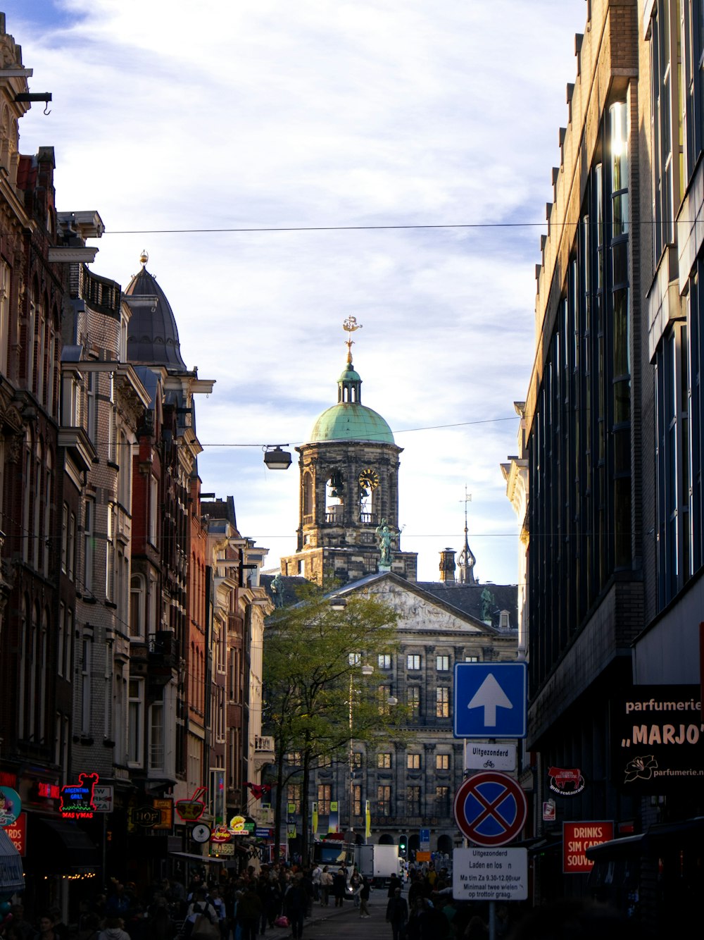 a city street lined with tall buildings and a clock tower