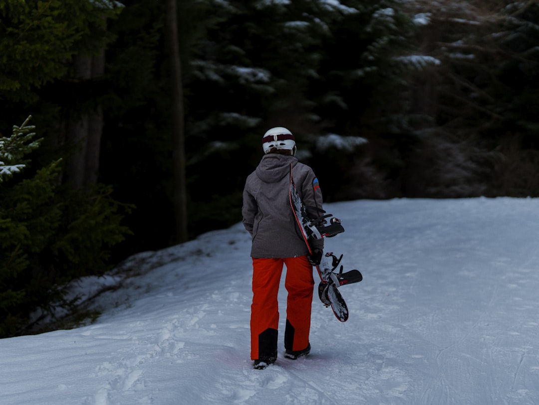 a person standing in the snow holding a snowboard,
