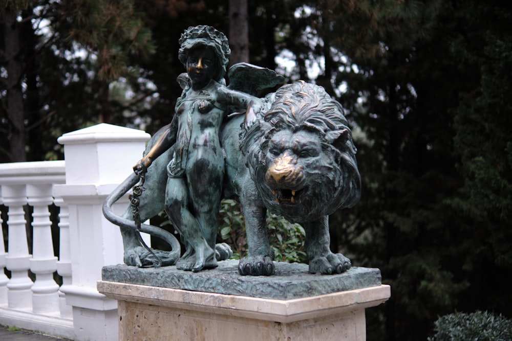 a statue of a woman and a lion on a pedestal