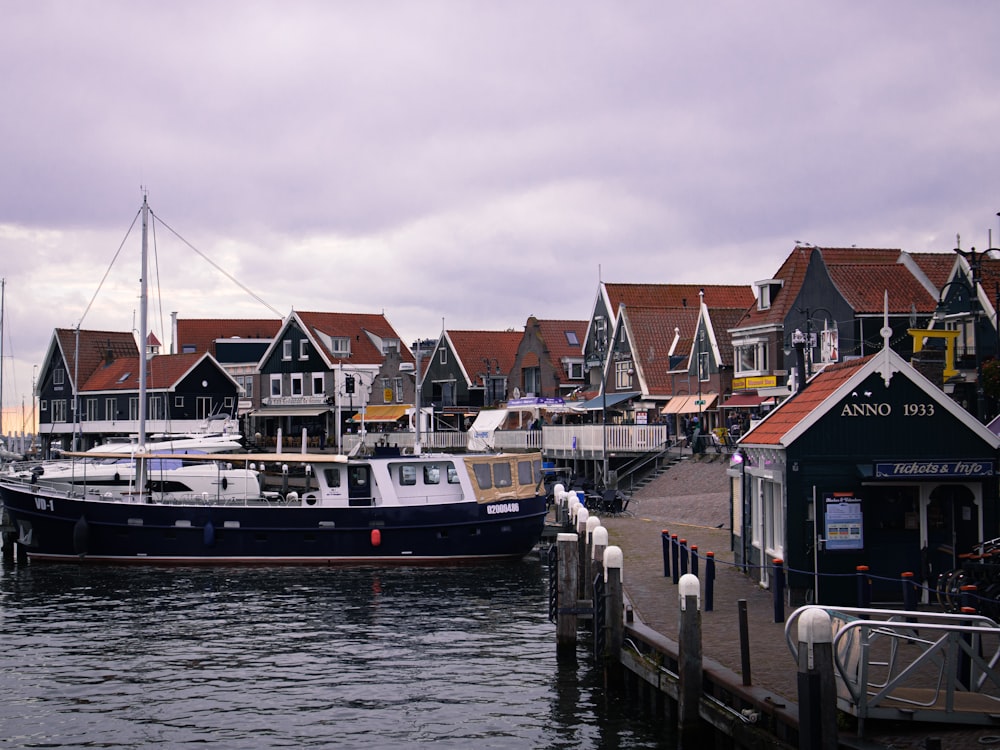 a boat is docked in a harbor with houses in the background