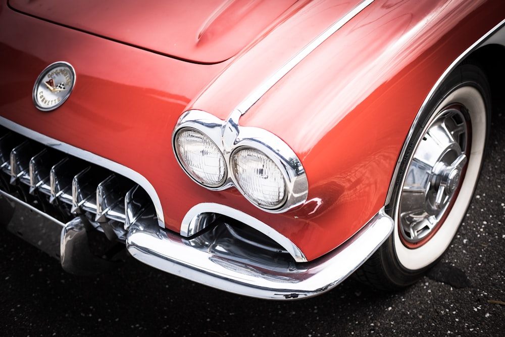 a close up of the front of a red classic car