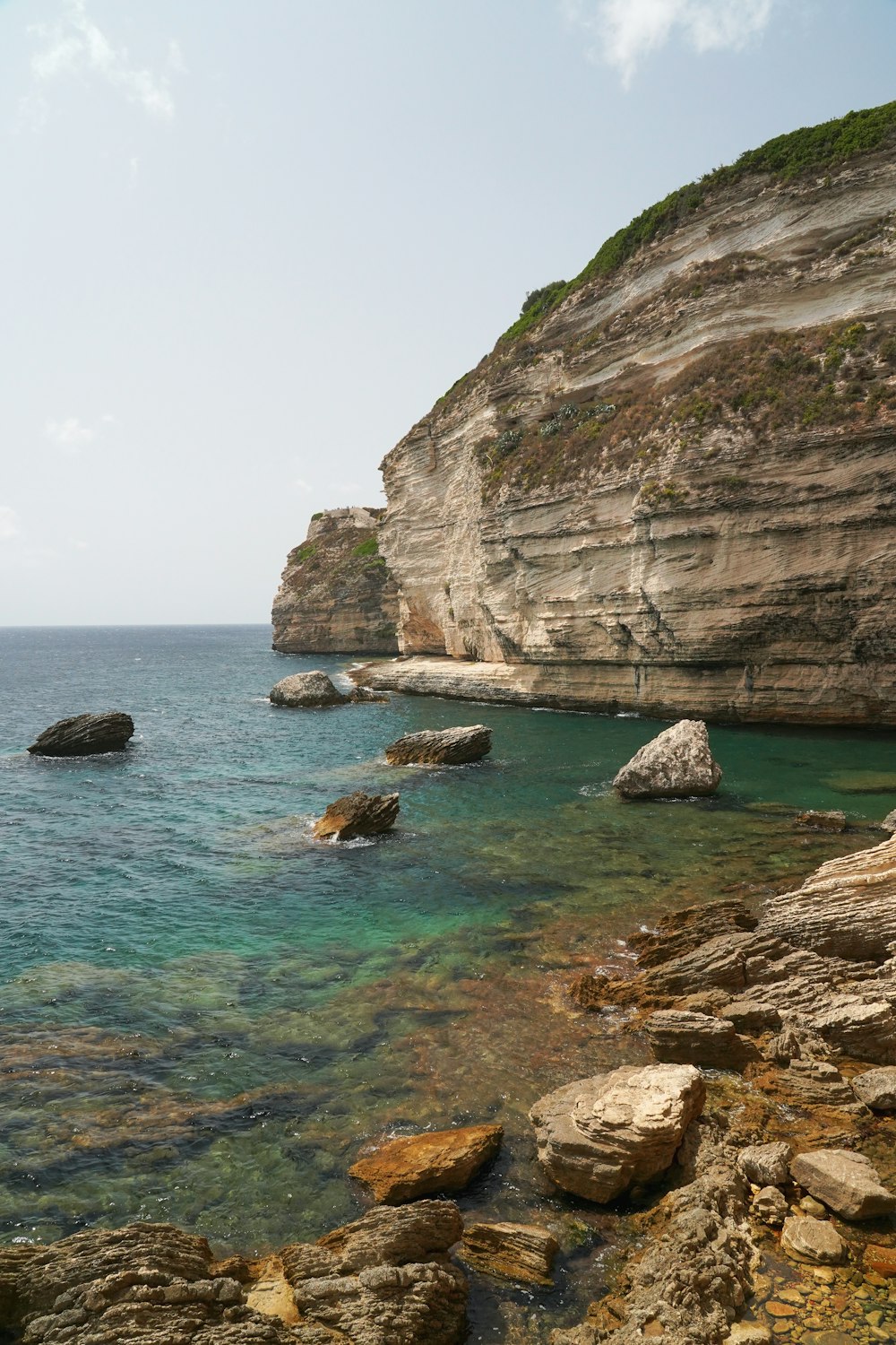 a body of water surrounded by rocks and a cliff