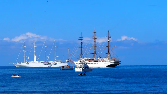 A vibrant scene of sailors collaborating on a sleek yacht under a clear blue sky.