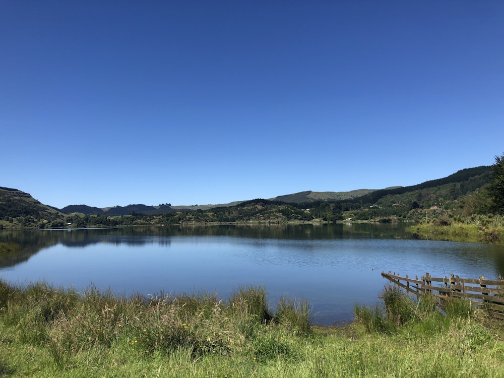 a body of water surrounded by a lush green hillside