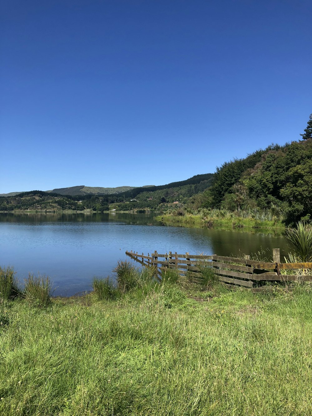 a large body of water surrounded by a lush green hillside