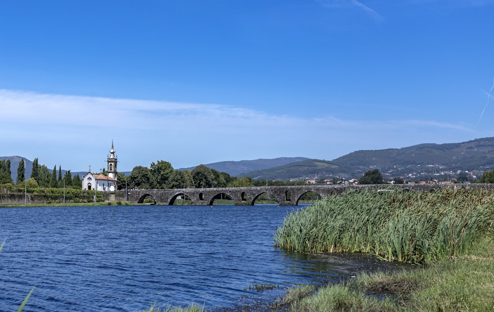 a bridge over a body of water with a church in the background