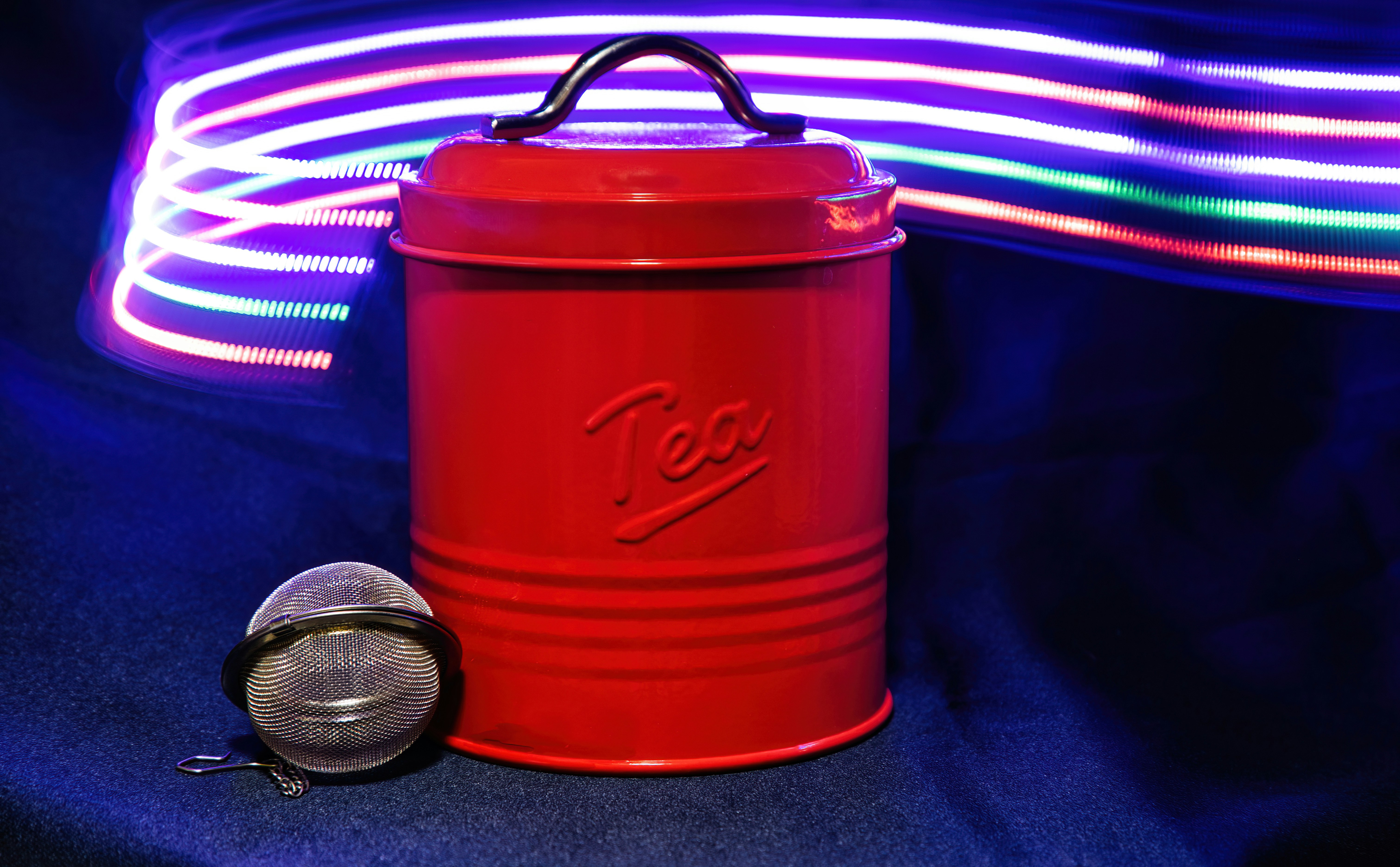 a red canister with a lit up neon background