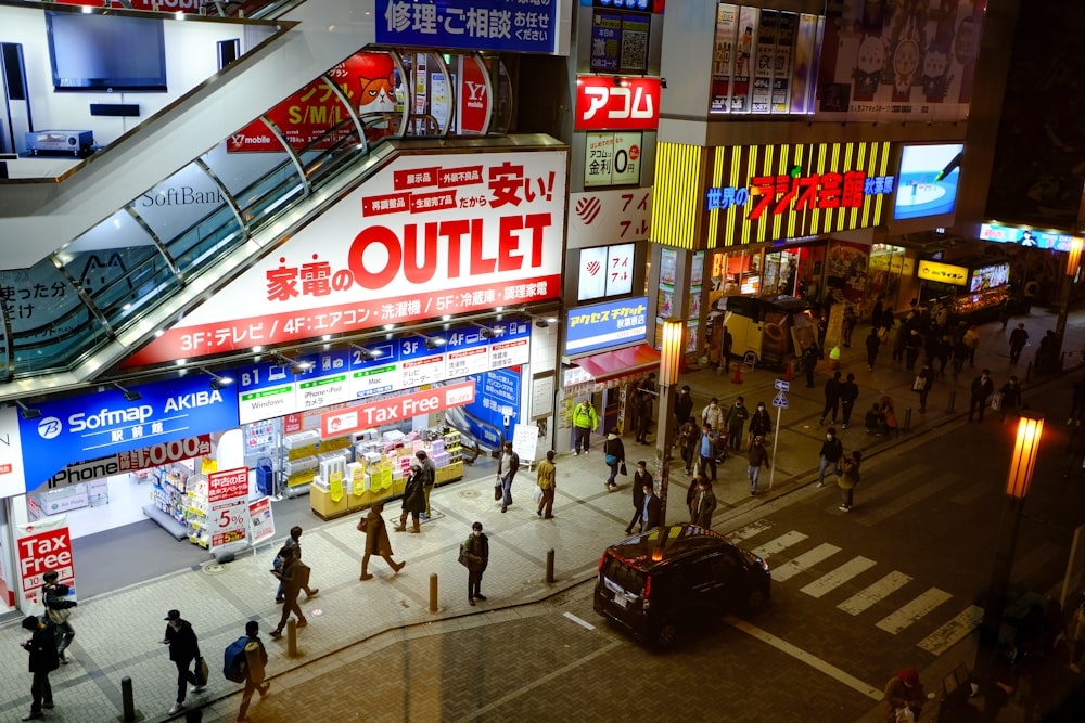 a busy city street at night with people walking around