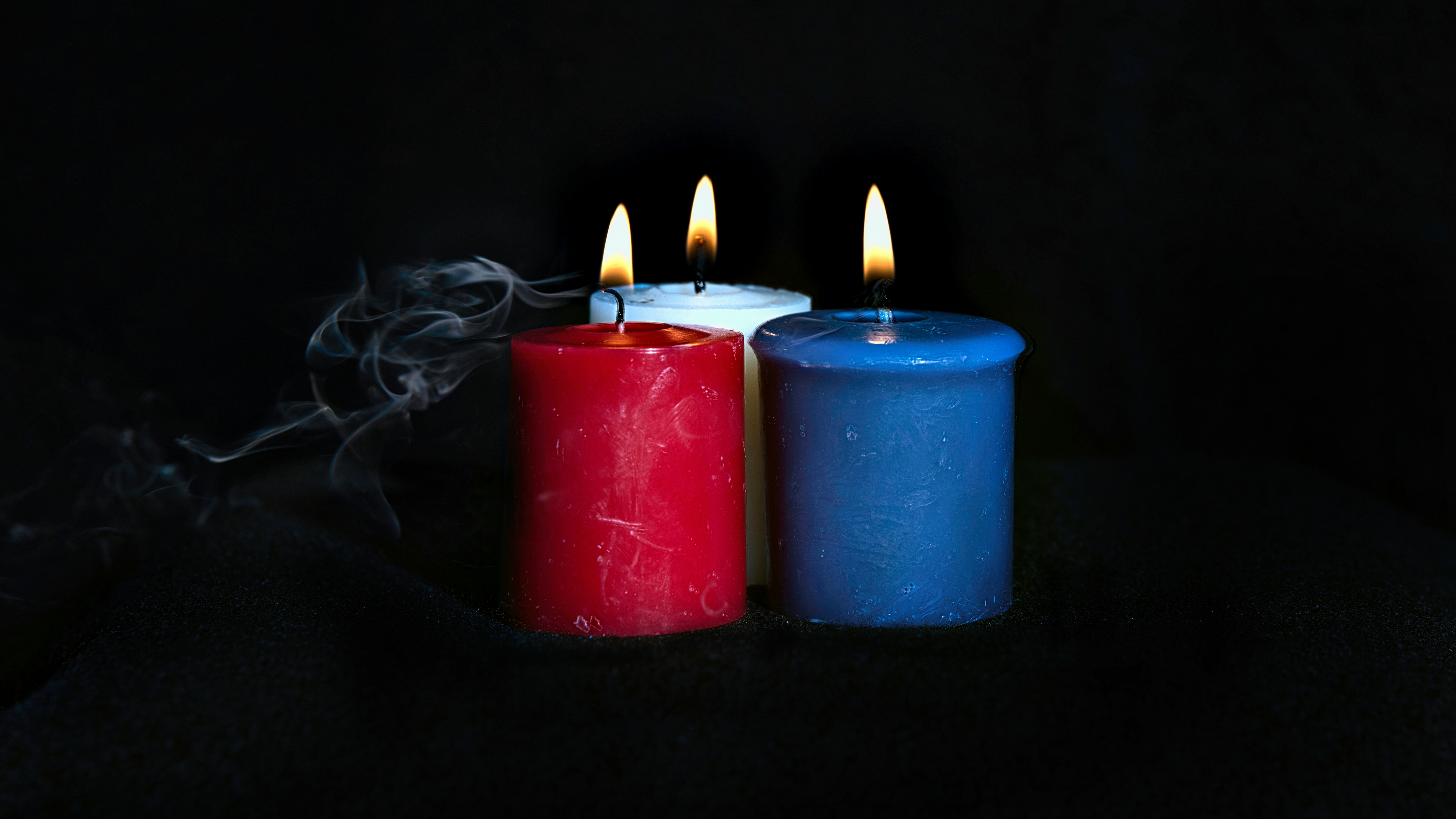 three lit candles sitting next to each other on a table