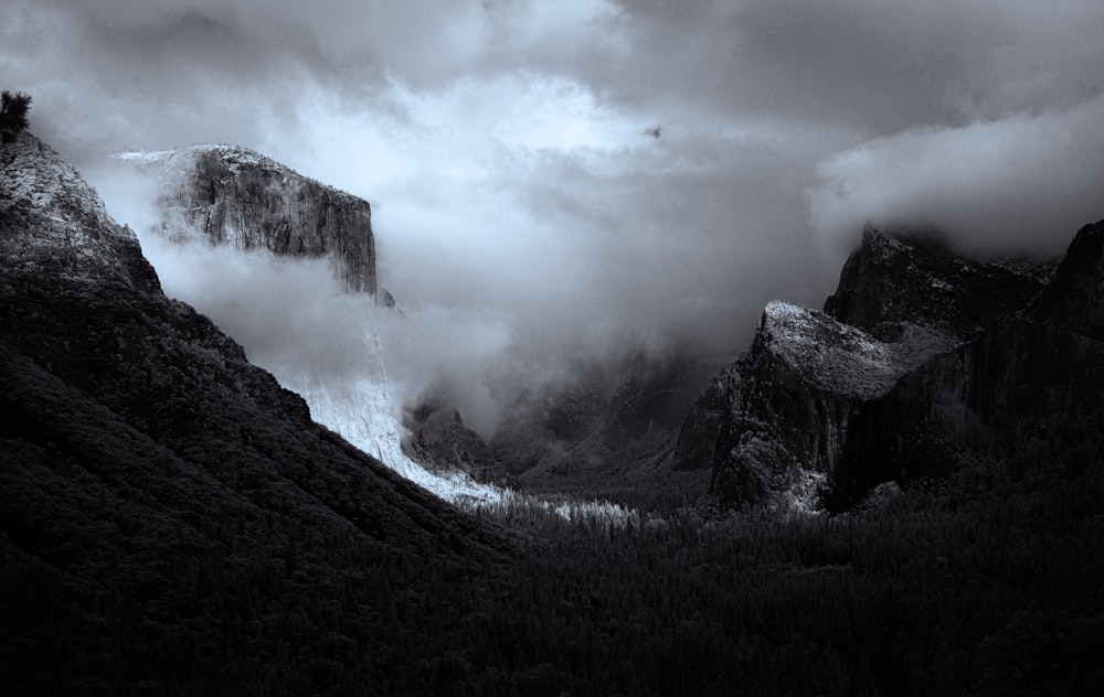 a black and white photo of mountains and clouds