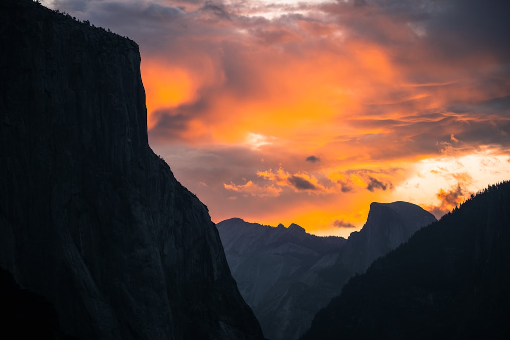 the sun is setting over a mountain range