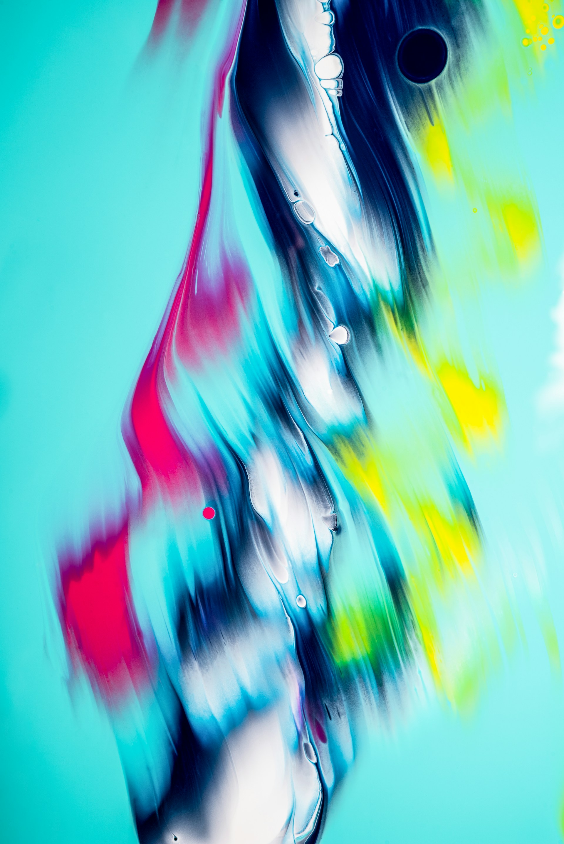Vibrant abstract artwork featuring flowing shapes and colors. Swirls of turquoise and white mix with bold red, yellow, and hints of dark navy blue, creating an impression of movement and energy.