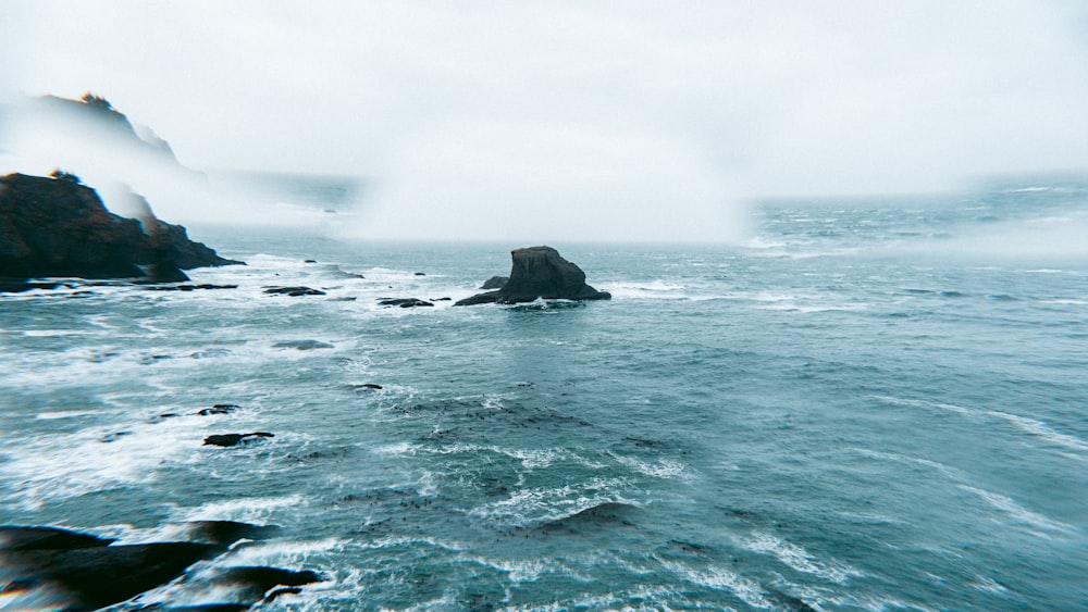 a large body of water with a rock in the middle of it