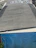 A small roof section with freshly placed tarp secured tightly, surrounded by modest shingle repairs.