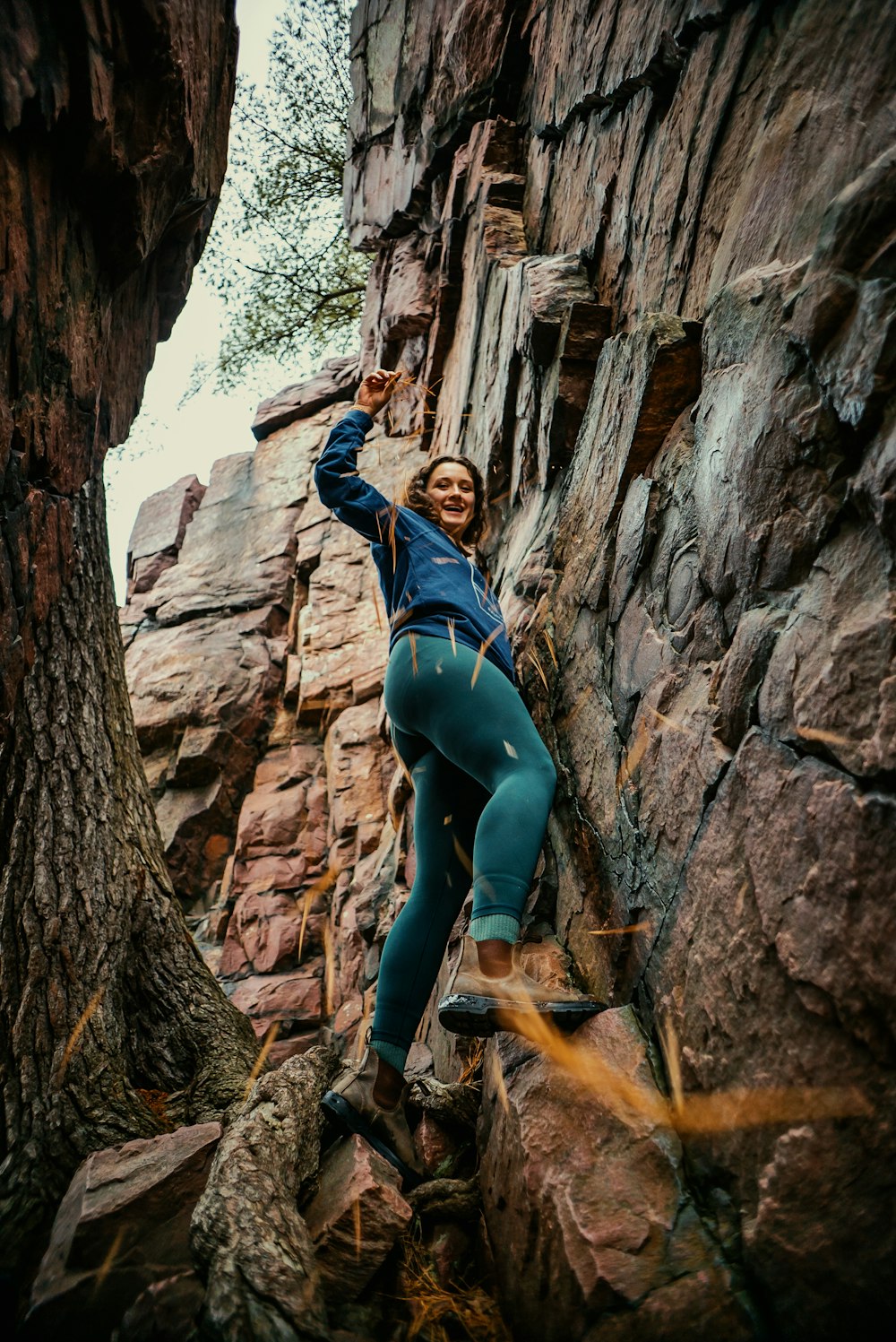 a woman climbing up the side of a mountain