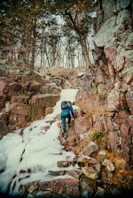 a man climbing up a snow covered mountain