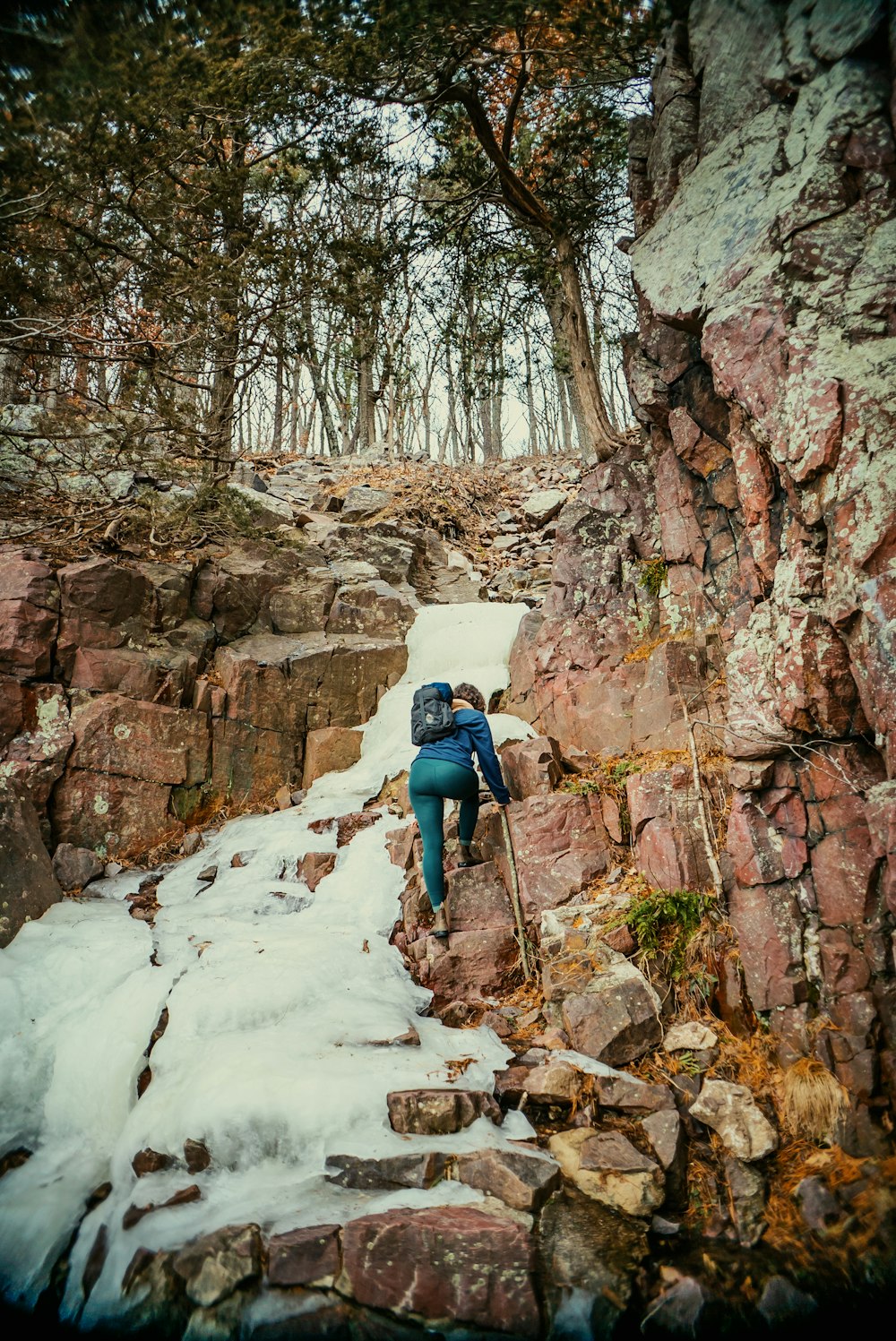 a man climbing up a snow covered mountain