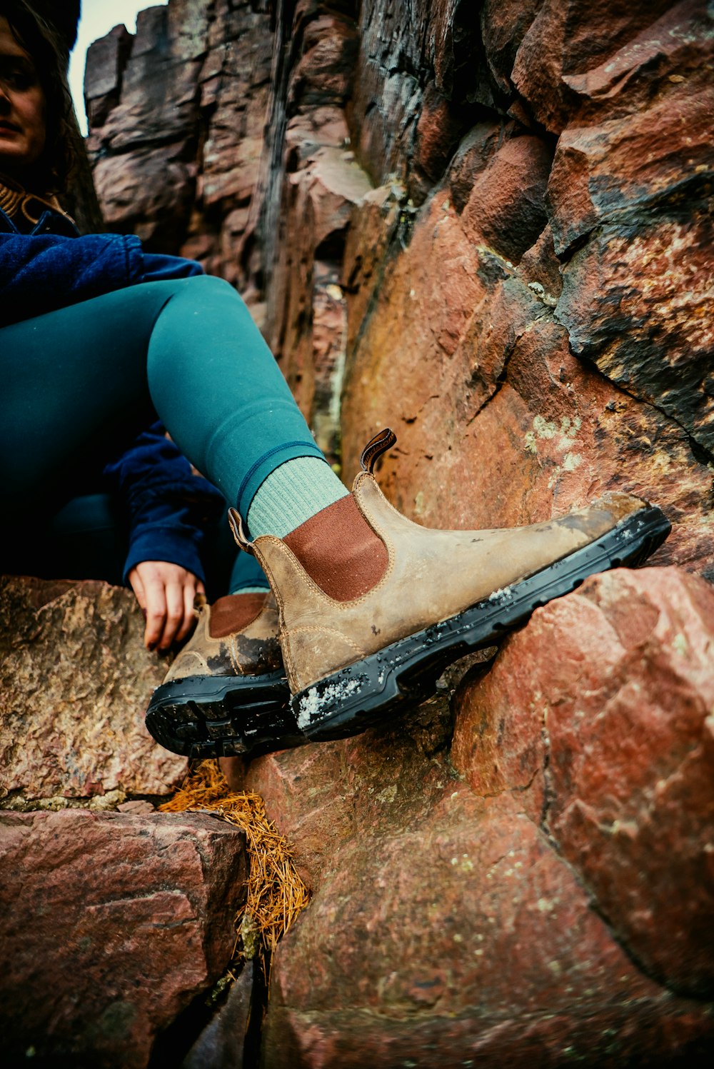 a person sitting on top of a large rock