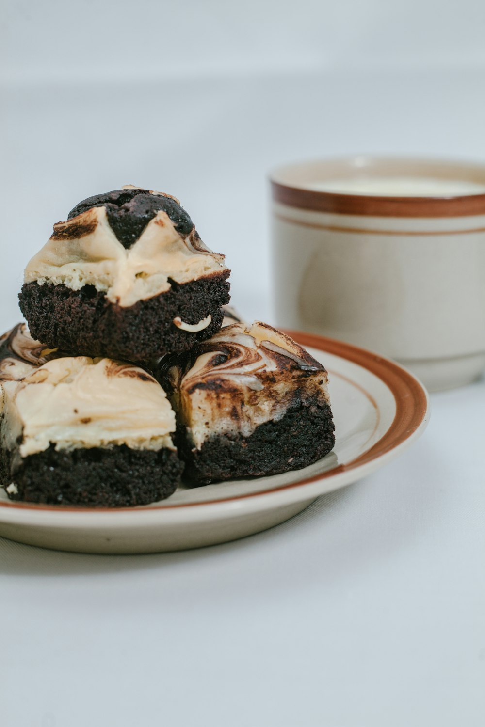 a white plate topped with brownies covered in frosting