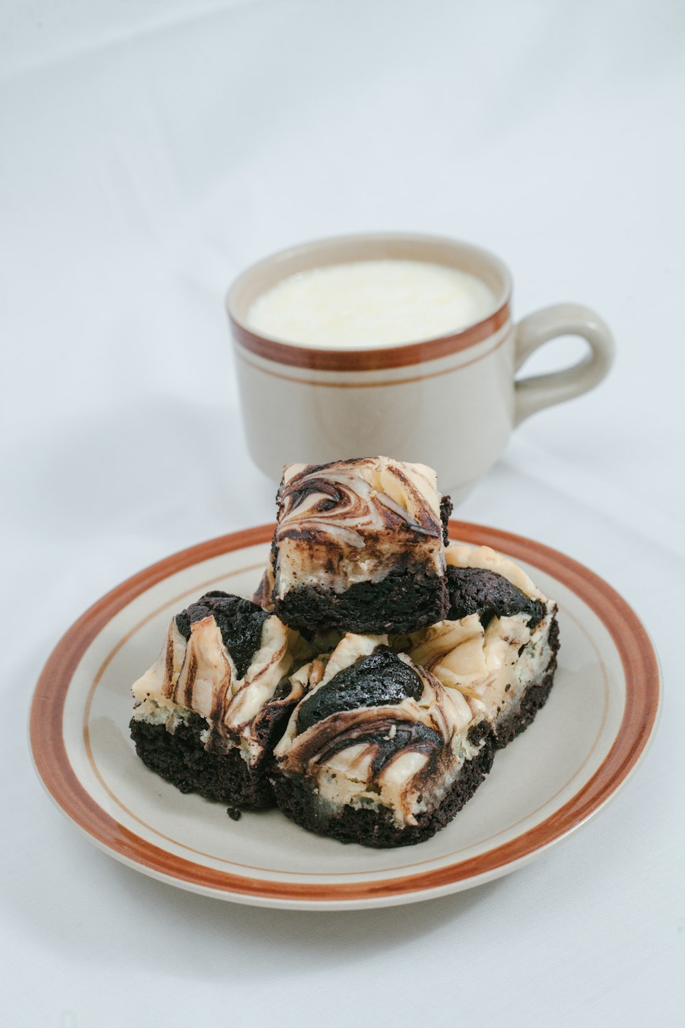 a white plate topped with brownies next to a cup of milk