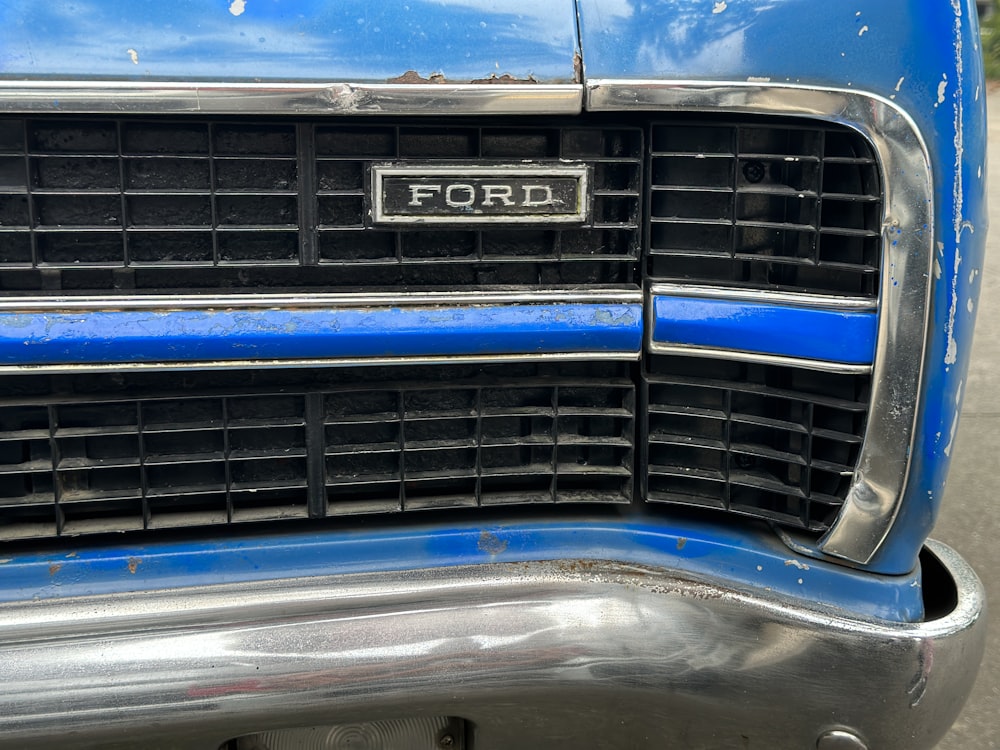 a close up of the front grille of a blue ford truck