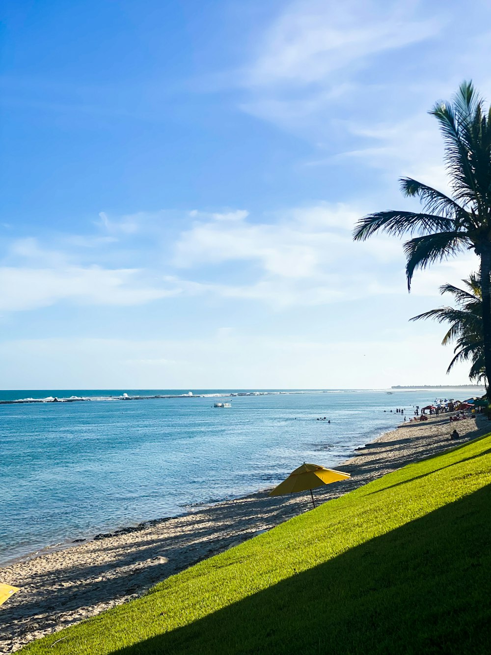 a view of a beach with a yellow umbrella